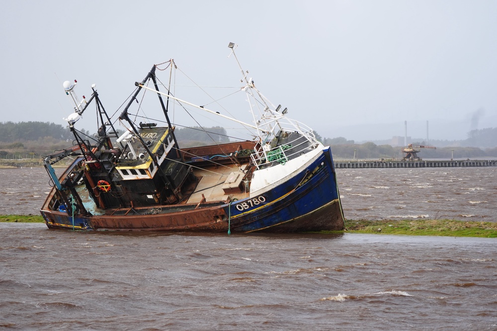 A fishing boat is stranded at Irvine Harbour in Ayrshire after coming loose from its moorings (PA)