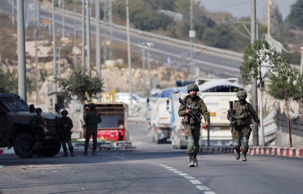 Israeli forces block a road during a military operation in Hebron (Reuters)