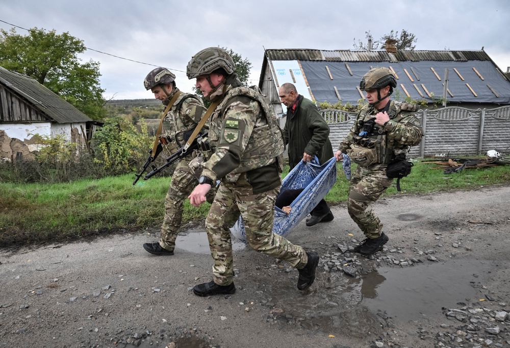File: Police officers evacuate a resident from the frontline rural settlement Komyshuvakha, amid Russia's attack on Ukraine, in Zaporizhzhia region, Ukraine 19 October 2026 (Reuters)