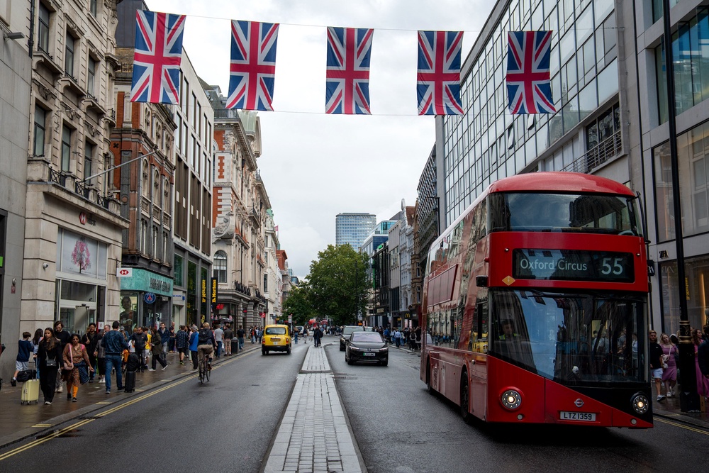 Pedestrians walk on the pavement beside vehicles being driven on Oxford Street in central London (AFP/Getty)