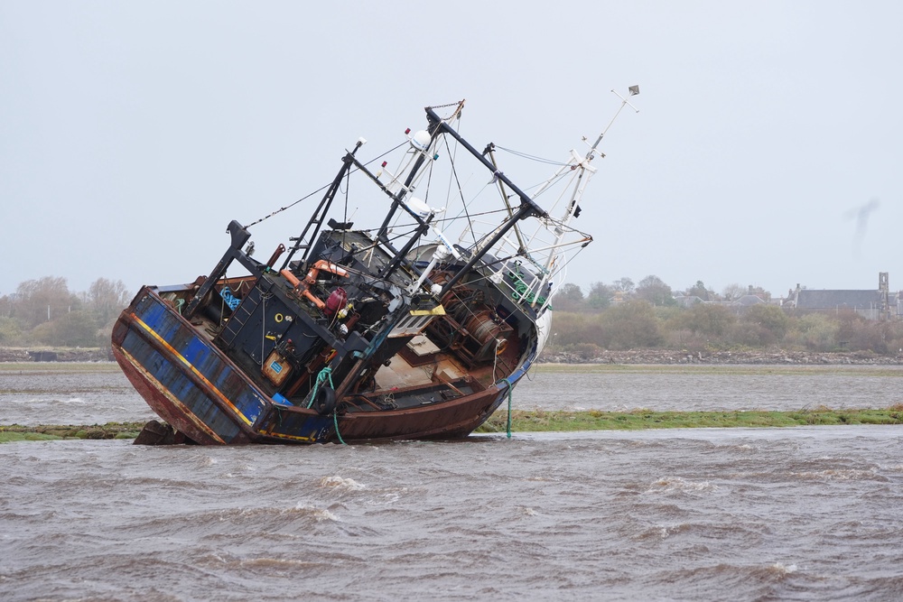 A fishing boat is stranded at Irvine Harbour in Ayrshire after coming loose from its moorings when Storm Boelo passed through the area (Jane Barlow/PA) (PA Wire)