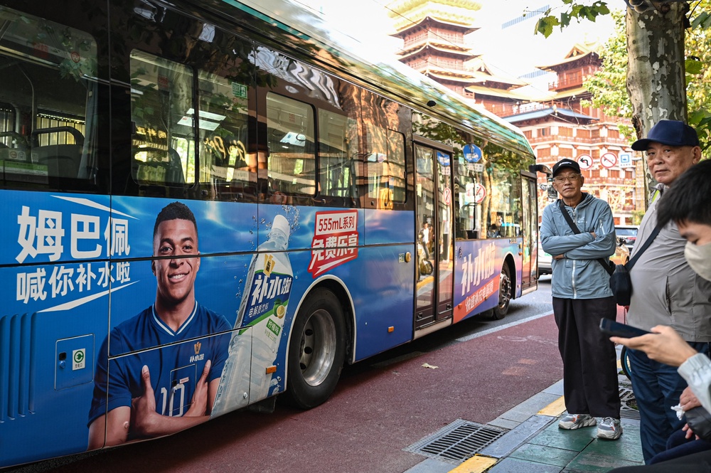 A bus featuring French football star Kylian Mbappe for Dongpeng Beverage Group's 'Bushuila' electrolyte drink is seen on a street in Shanghai on October 27, (AFP/Getty)