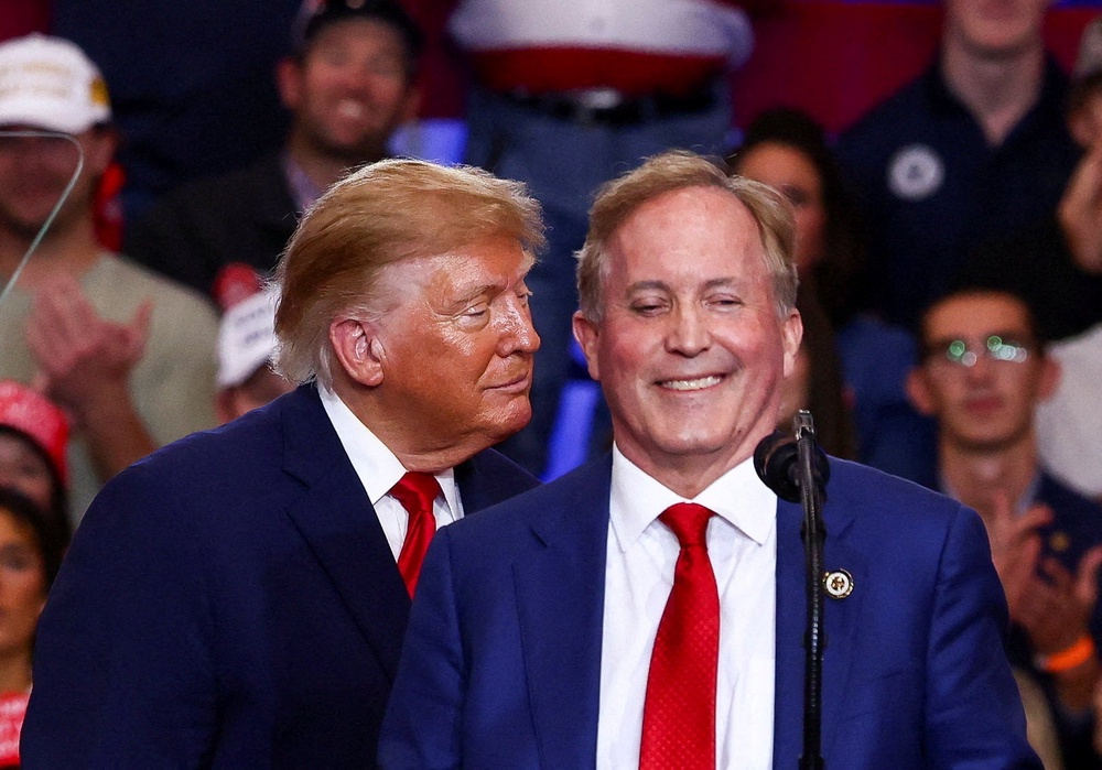 Paxton reacts during a midterm election rally beside  Trump, in Lubbock, Texas (Reuters)
