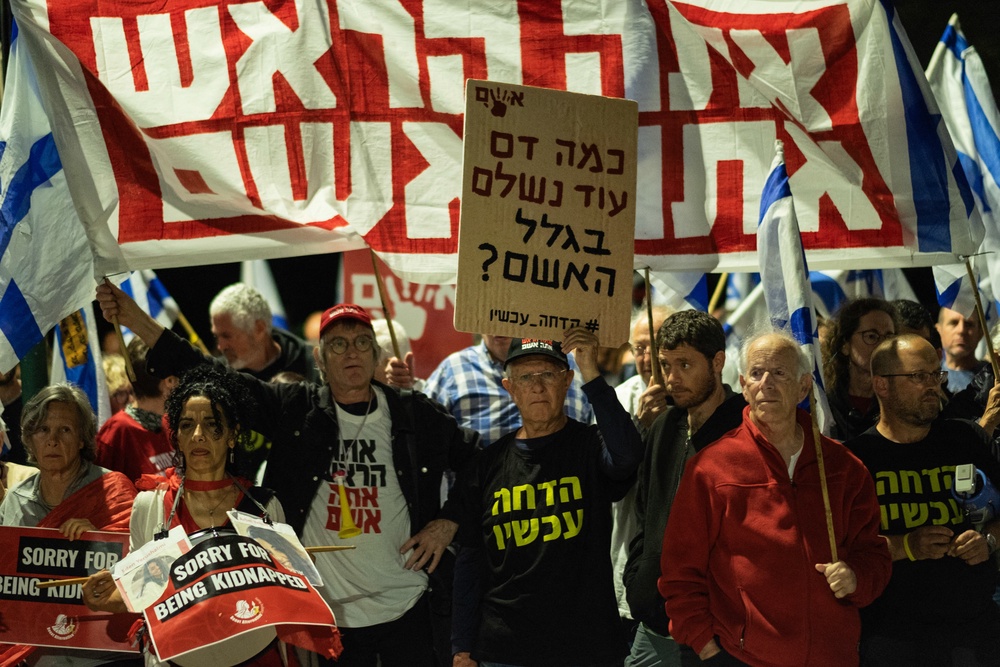 A group of protesters holds banners reading 