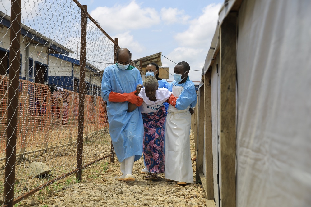 Healthcare workers help a patient who was cleared of Ebola virus inside a treatment center for Beni, North Kivu province, eastern Congo, (AP)