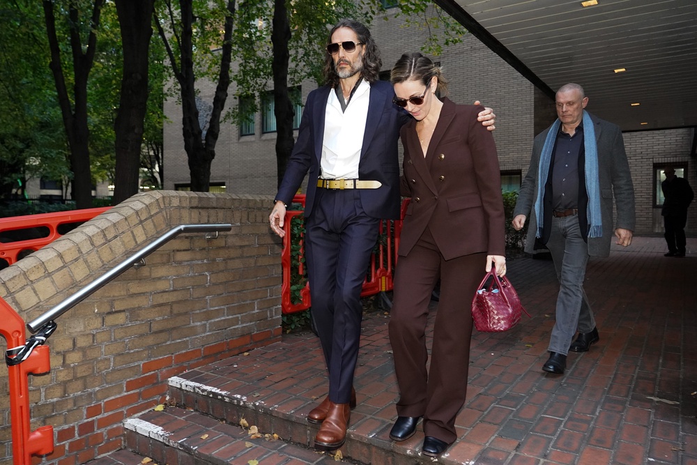 Russell Brand and his wife Laura Gallacher pictured leaving court (Getty)