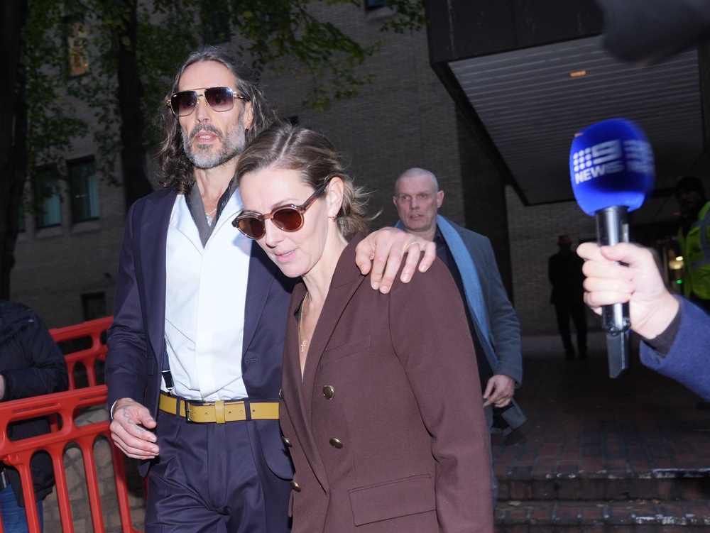 Brand leaving  court with his wife, Laura Gallacher (PA)