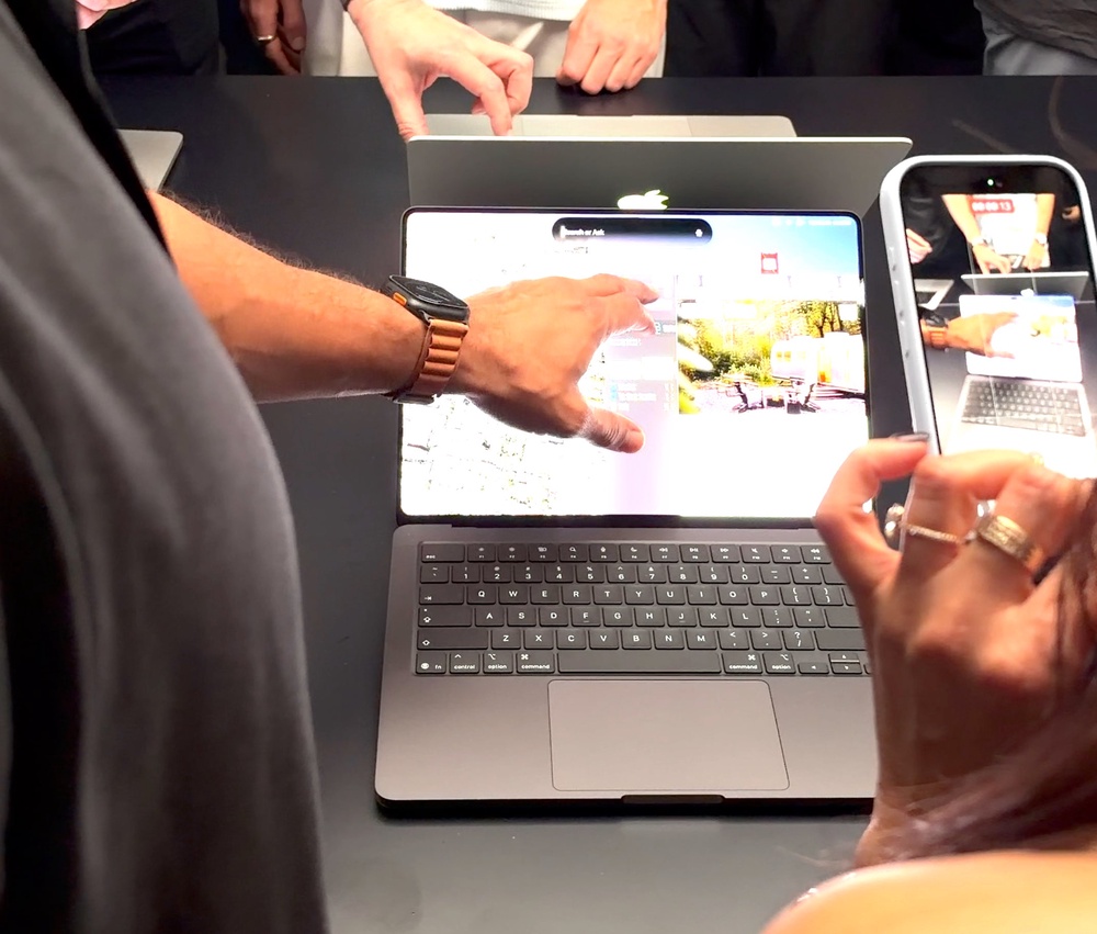 Touching the new MacBook Pro at the launch event (Andrew Griffin/The Independent)