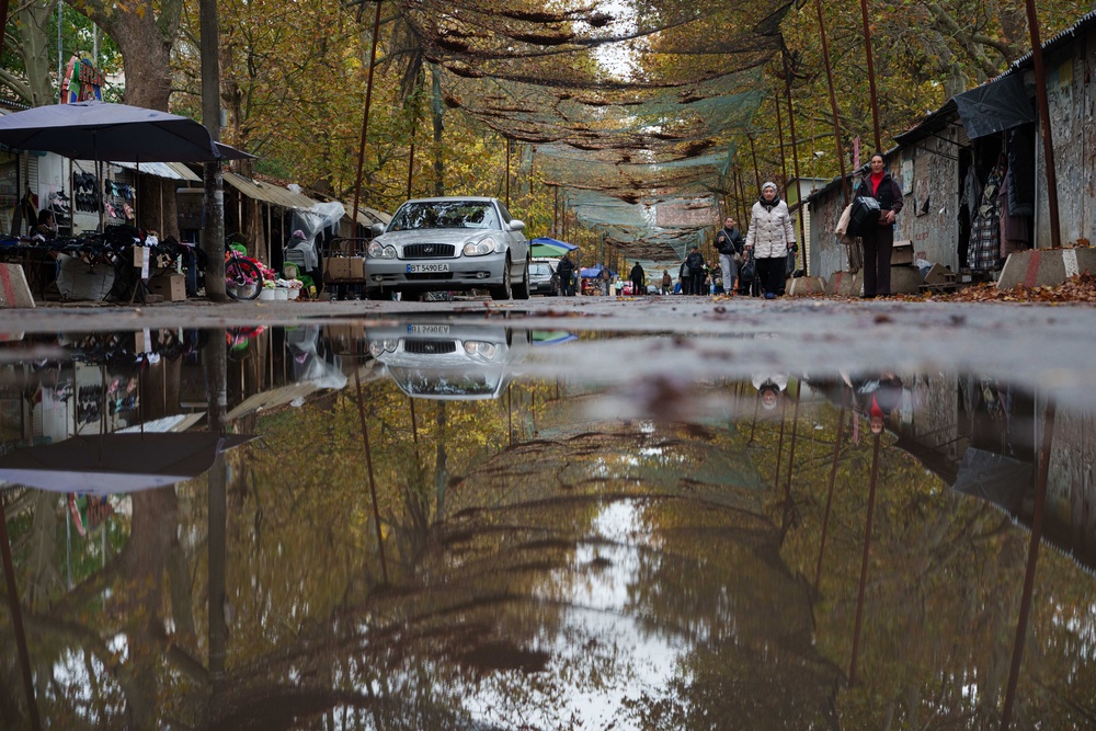 People walk through a local market beneath anti-drone nets stretched over a street in Oleshky (AP)