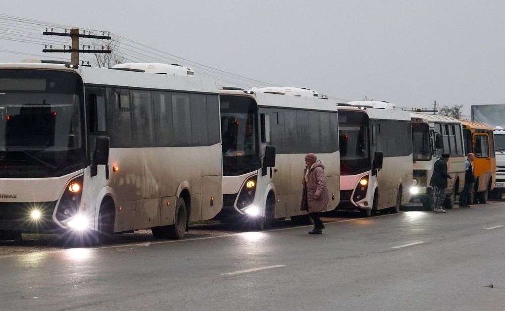 A humanitarian convoy carrying residents evacuated from Oleshky, during a brief stop (Reuters)