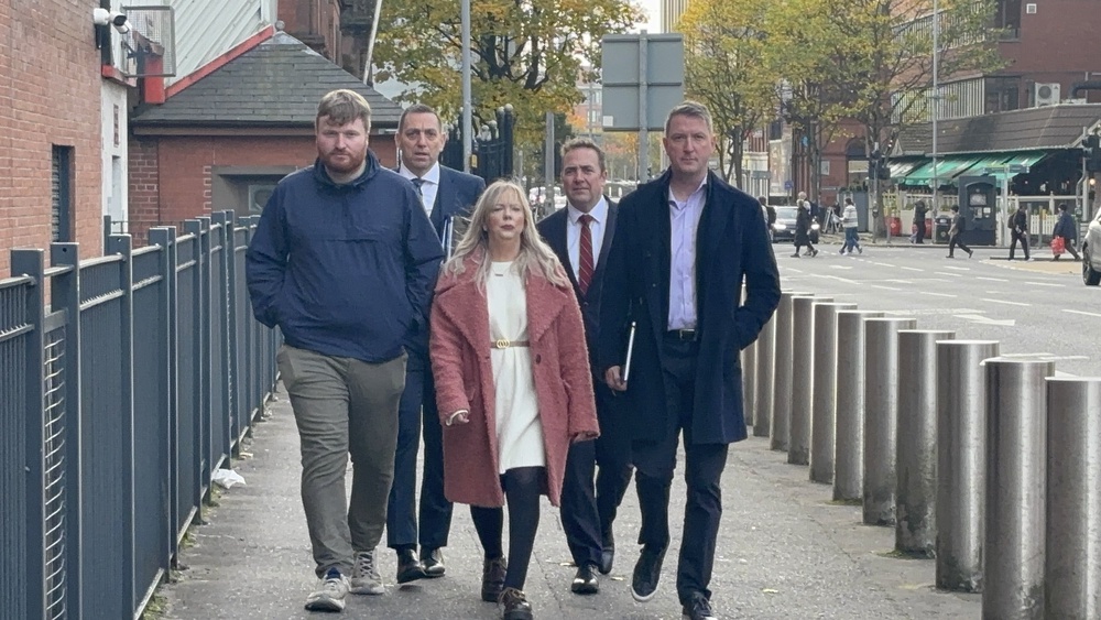 Sinn Féin councillor Catherine Nelson accompanied by North Belfast MP John Finucane (right) and solicitor Padraig O Muirigh (second left) arriving at Musgrave Police Station (Rebecca Black/PA) (PA Wire)