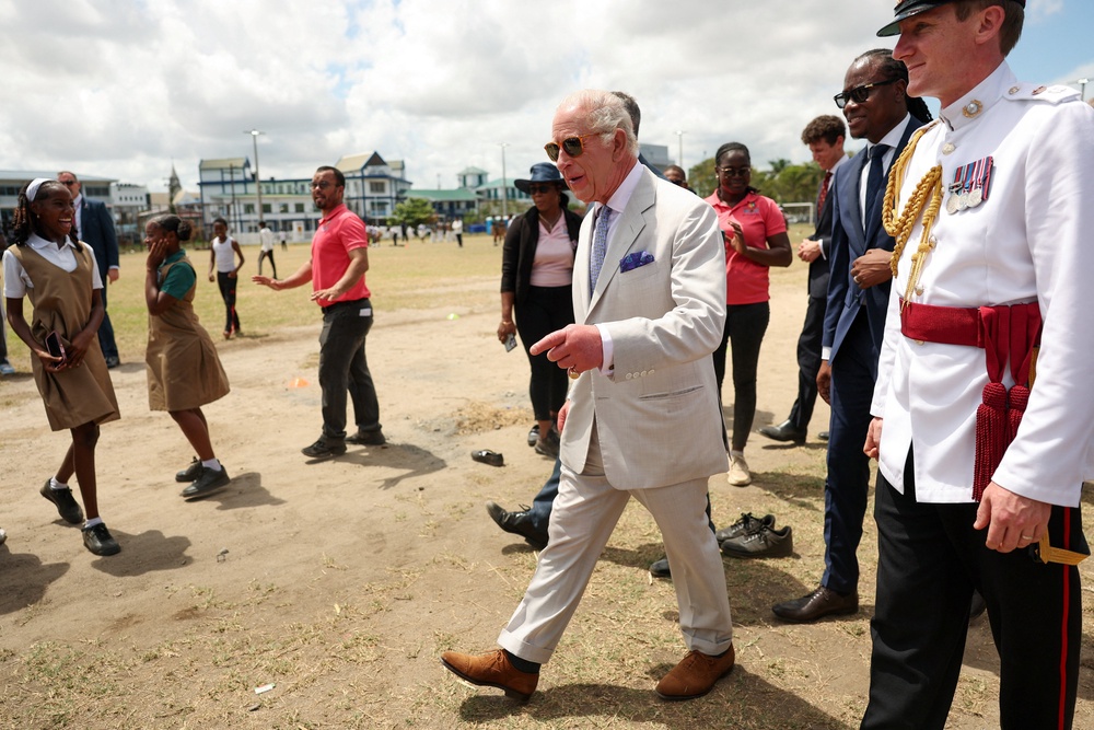 Charles with Steven Jacobs, as he greets youths in Promenade Gardens next to Independence Park in Georgetown (Isabel Infantes/PA) (PA Wire)