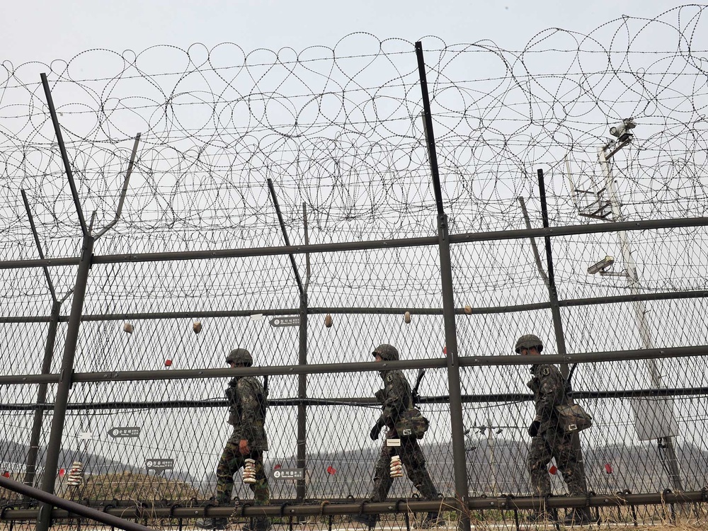 Soldiers walk along the fortified border between North Korea and South Korea