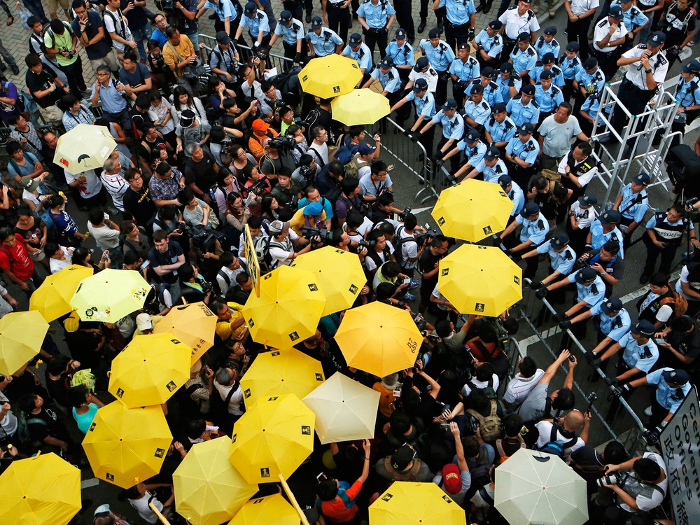 Protesters observe a moment of silence to mark the first anniversary of the ‘Umbrella Movement’ outside the government HQ in Hong Kong (AP)