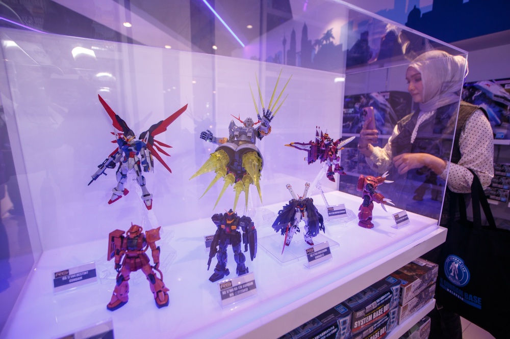 A visitor takes a photo of assembled Gunpla models on display inside the newly opened Gundam Base brand store at Fahrenheit88 in Kuala Lumpur on April 14, 2026. — Picture by Raymond Manuel