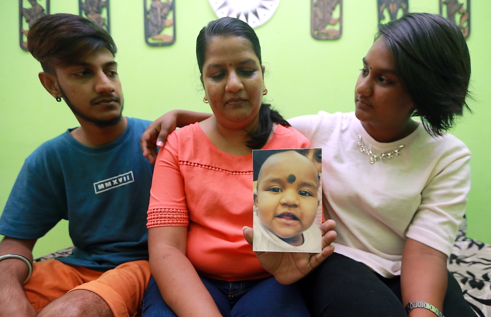 Karan Dinish and Tevi Darsiny, aged 19 and 20 then in 2017, with their mother M. Indira Gandhi and the only photo they have of Prasana Diksa as a baby. — Picture by Farhan Najib 