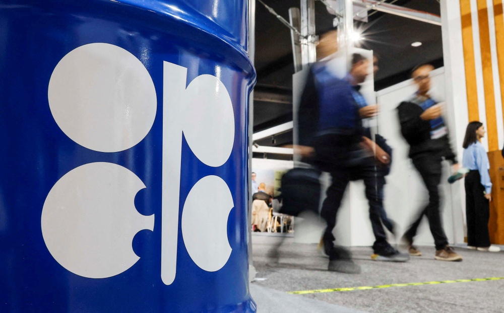 People walk past an installation depicting a barrel of oil with the Opec logo during the COP29 United Nations climate change conference in Baku on November 19, 2024. — Reuters pic