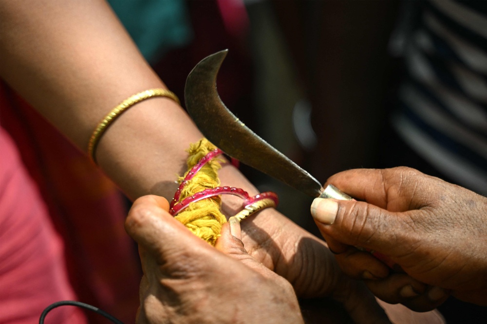 Thilothama, a tansgender, gets her bangles broken by a priest symbolising end of her marriage to Hindu warrior god Aravan during the annual Koovagam transgender festival at the Koothandavar temple in Tamil Nadu's Kallakurichi district. — AFP pic