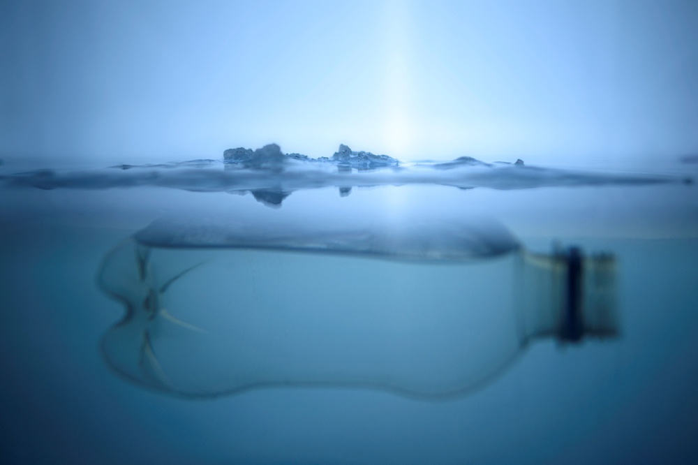 A file illustration shows a plastic bottle floating below a layer of ice in Vaasa on December 8, 2022. — AFP pic