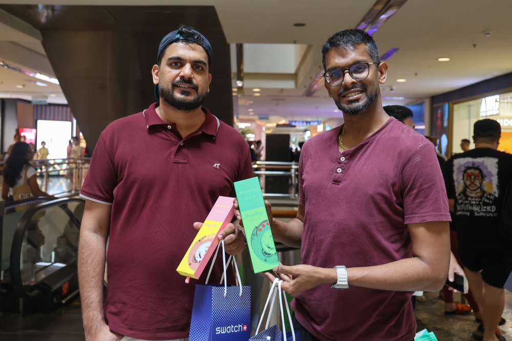 Ammanjit Singh, 39 (left) poses for pictures with his friend after buying the Swatch X Audemars Piguet Royal Pop watches at Mid Valley Megamall in Kuala Lumpur on May 16, 2026. — Picture by Yusof Isa