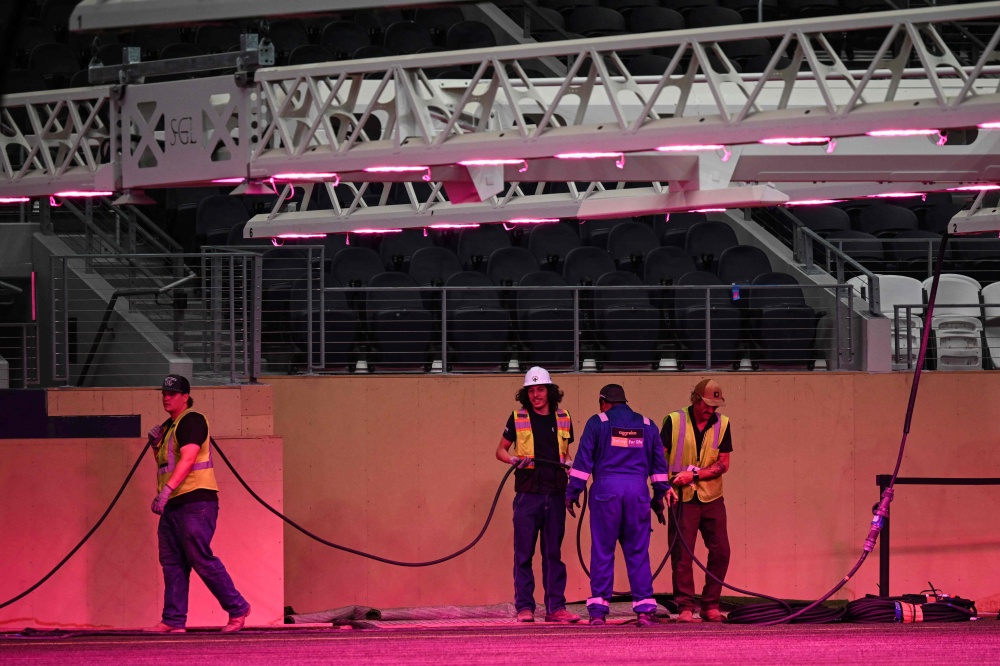 Workers are seen at Dallas Stadium (temporarily renamed from AT&T Stadium for the 2026 FIFA World Cup) with purple lights illuminating the field to promote grass growth, in Arlington, Texas, on May 14, 2026. — AFP pic