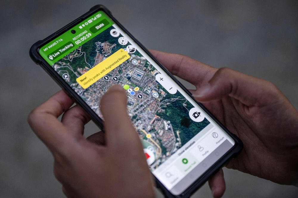 Langur Project Penang (LPP) project executive Wong Hui Yi uses a ‘live’ tracking application to monitor dusky langurs at a playground near residential buildings in the Tanjung Bungah area of George Town April 9, 2026. — AFP pic