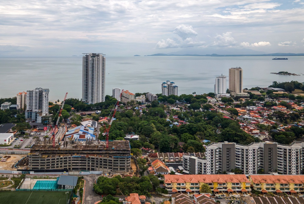 A view of a green area with dense trees where langur monkeys can be found surrounded by residential buildings and hotels at the Tanjung Bungah area of George Town April 9, 2026. — AFP pic