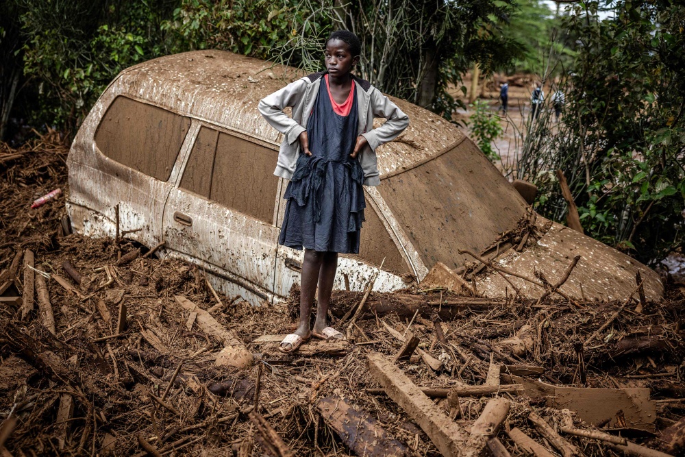 File picture of a girl beside a mud‑buried car in Kamuchiri village near Mai Mahiu, Kenya, on April 29, 2024, after torrential rains and flash floods triggered by a dam burst killed at least 45 people during the El Nino‑compounded wet season. — AFP pic