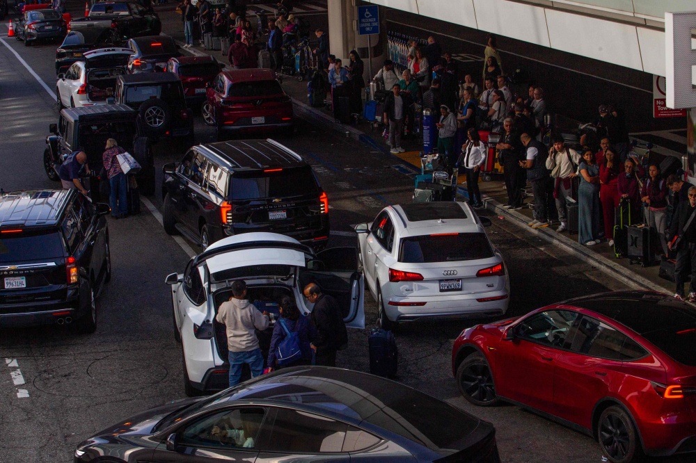 People wait for their ride and cars stop to pick up travellers at the arrival area of Los Angeles International Airport (LAX) in Los Angeles, California, on May 15, 2026. — AFP pic