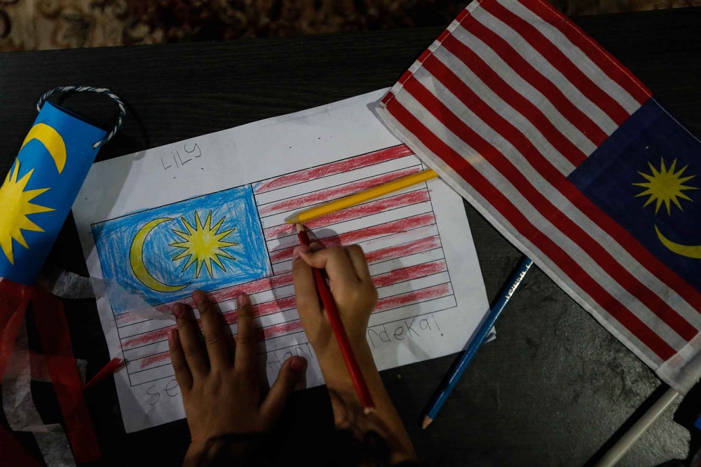 File picture of a toddler colouring the Malaysian flag in Kepala Batas, August 31, 2021. — Picture by Sayuti Zainudin 