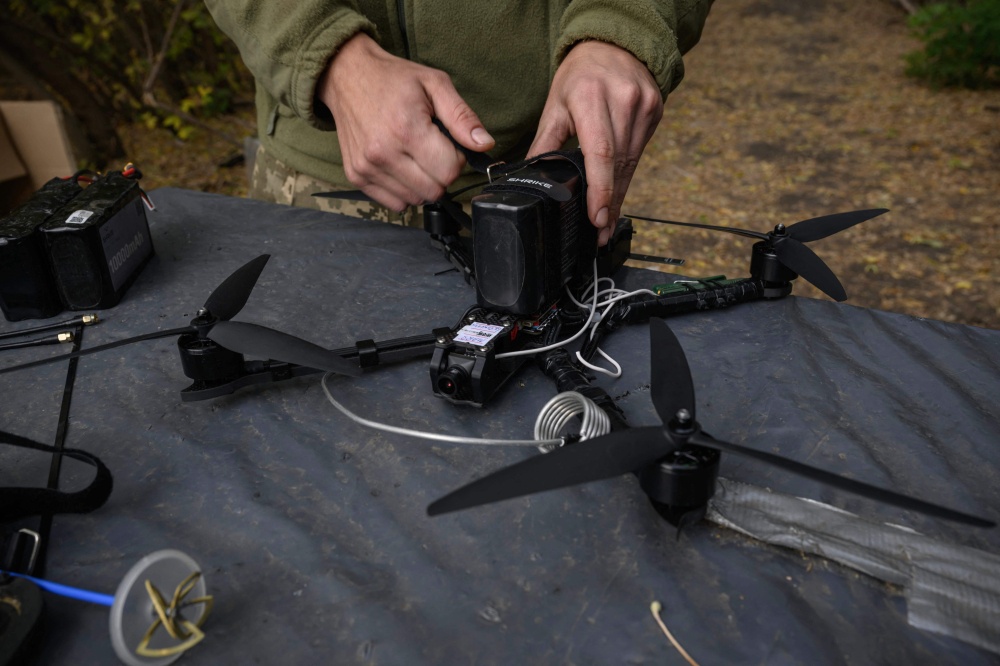 A Ukrainian soldier of the Black Wing unit, 116th Mechanized Brigade, tests an FPV drone at a workshop facility at an undisclosed location near the front line in the Kharkiv region of eastern Ukraine on October 8, 2025. — AFP pic