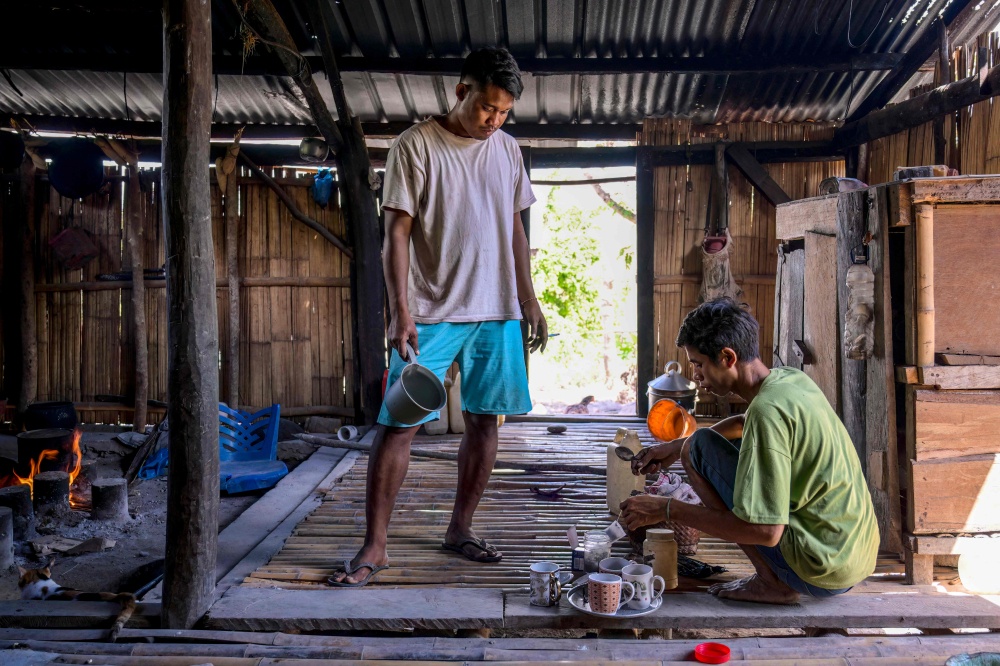 This photo taken on June 23, 2026 shows Umbu Ana Rara (L), a maramba (nobleman), looking on as his ata (slave), Kanisius Kanyali Hambarita, prepares drinks at Tanggedu village in East Sumba, East Nusa Tenggara. — AFP pic