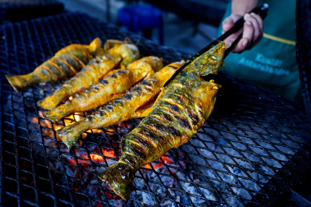 Warung Dayang Salai D’Linggi owner Rozianah Ahmad, 57, prepares smoked ‘baung’ for her curry in Port Dickson. — Bernama pic