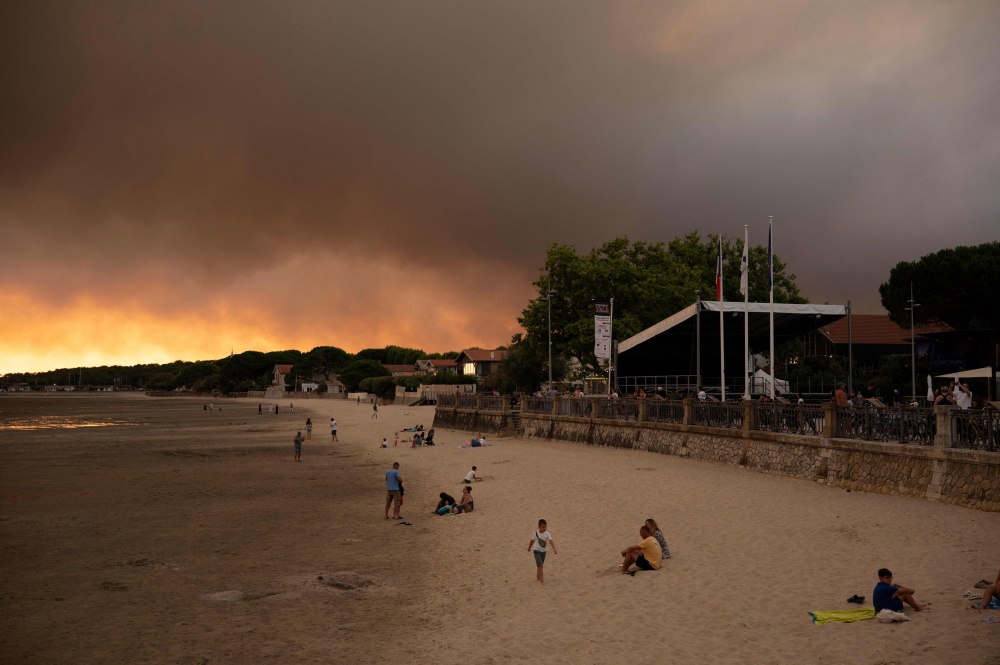 This picture shows people on the beach in Andernos-Les Bains during fire in Lege Cap-Ferret forest, southwestern France on July 23, 2026, as part of the nearby area has been evacuated. — AFP pic