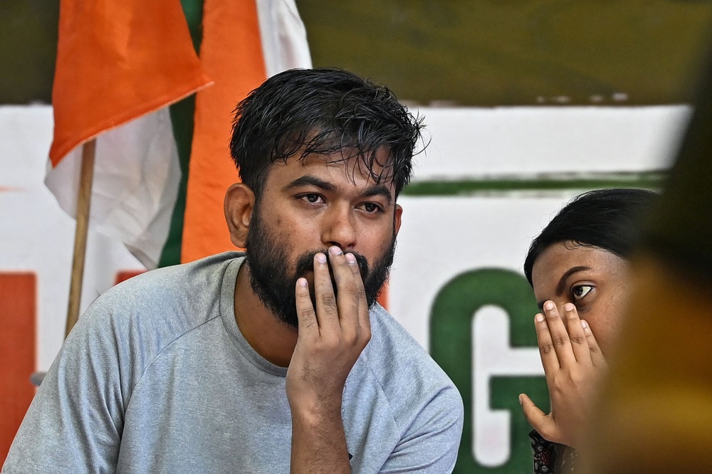 Cockroach Janta Party (CJP) founder Abhijeet Dipke (left) sits on an indefinite hunger strike demanding the resignation of India's Education Minister Dharmendra Pradhan over alleged NEET examination irregularities in New Delhi on July 19, 2026. — AFP pic