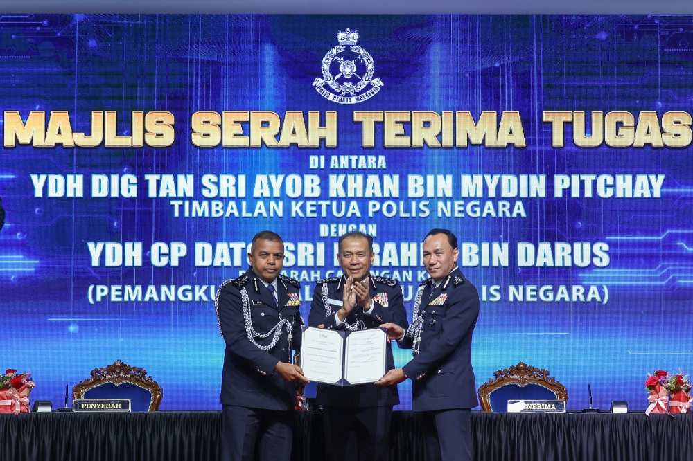 Deputy IGP Tan Sri Ayob Khan Mydin Pitchay (left) hands over duties to successor Datuk Seri Ibrahim Darus (right) as IGP Tan Sri Mohd Khalid Ismail (centre) looks on during the handover and farewell ceremony at Pulapol, Kuala Lumpur, July 26, 2026. — Picture by Yusof Isa
