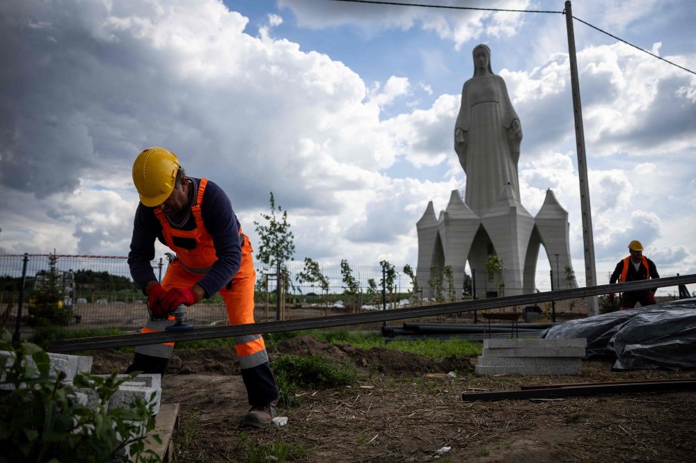 A worker is seen on the construction site where finishing works are being carried out on the statue of the Virgin Mary in Konotopie village, next to Torun, central Poland, on July 22, 2026. — AFP pic