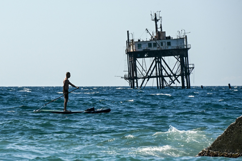 A man rides a stand‑up paddleboard in the Black Sea at Simeiz, Crimea, on July 22, 2026. — AFP pic