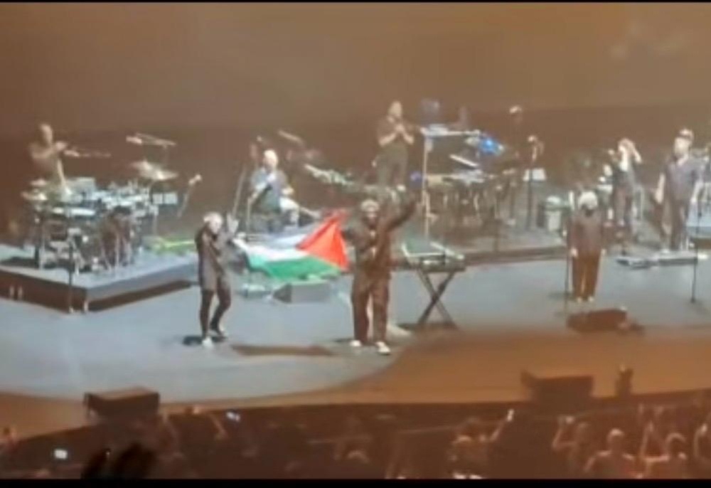 Two members of British band Massive Attack hold up a Palestinian flag on stage during a July 29, 2026 concert in Singapore’s The Star Theatre, violating local laws banning the display of foreign national emblems without a permit. — Screengrab from Instagram/sgpowerlah