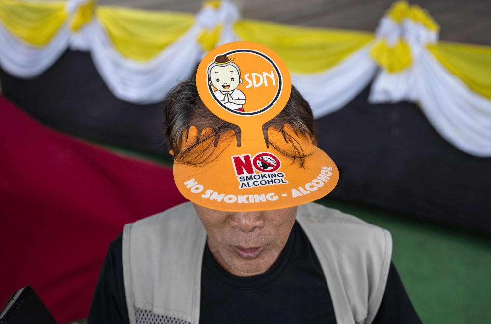 People pledge to abstain from drinking alcohol for three months to mark the start of Buddhist Lent at Wat Nong Song Hong in Samut Sakhon province on July 30, 2026. — AFP pic