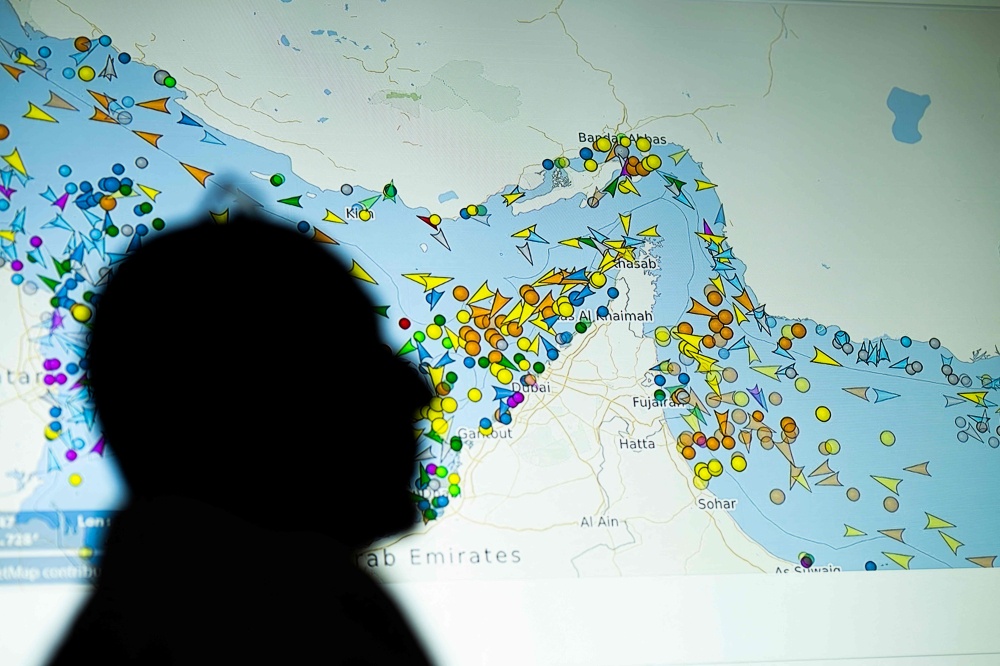 A photo illustration shows a person in front of a large screen displaying vessel movements in the Strait of Hormuz on a ship-tracking website in Nicosia on May 4, 2026. — AFP pic