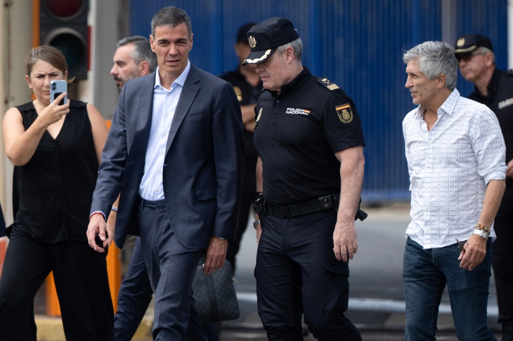 Spain’s Prime Minister Pedro Sanchez (C) and Minister of Interior Fernando Grande Marlaska (R) walk by the Tarajal border fence between Spain’s North Africa’s Ceuta enclave and Morocco during a visit on July 31, 2026. — AFP pic