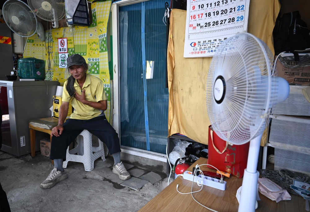 The heatwaves are not experienced equally across the wealth divide. — AFP pic