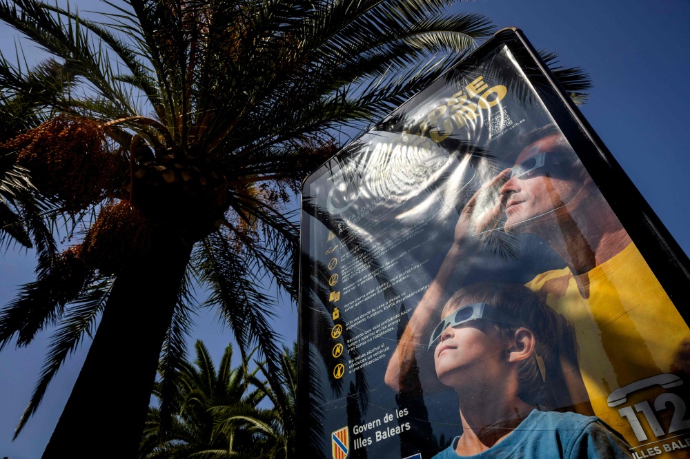 An information panel displays measures on how to safely view an upcoming solar eclipse on a street in Palma de Mallorca on July 31, 2026. — AFP pic