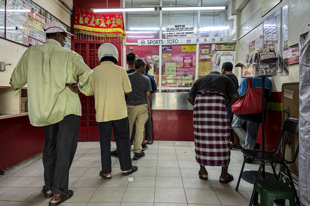 File picture of a lottery shop in Selangor, with a sign at the lottery ticket counter stating the messages as required by the Finance Ministry as conditions for the annual pool betting business licence. — Picture by Hari Anggara