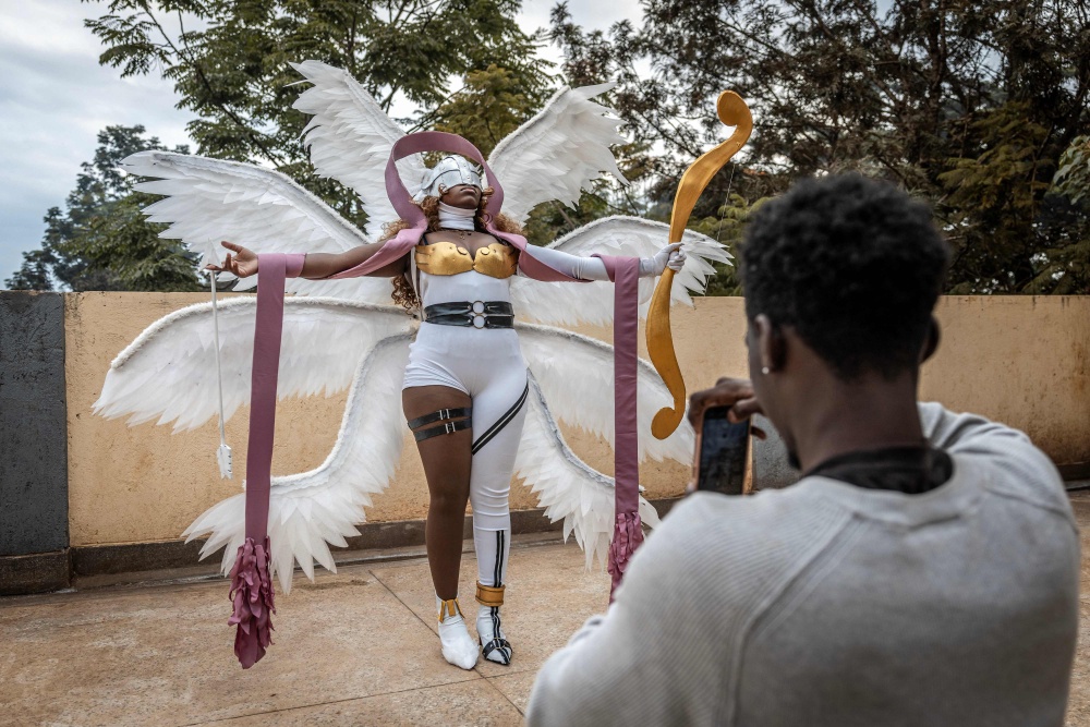 Cosplayer Yvonne Chockey creates content with a friend for her social media accounts while cosplaying as Angewomon, a character from the popular Digimon anime series, ahead of the Otamatsuri convention at the rooftop of her home in Kutus on August 17, 2026. — AFP pic