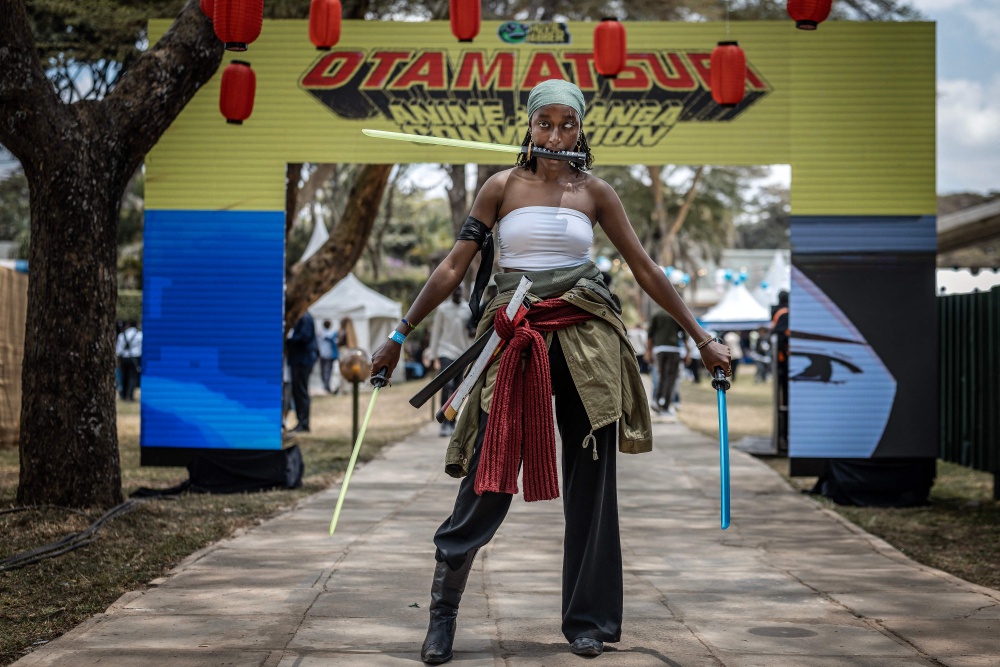 A cosplayer dressed as a character from the popular manga and anime series One Piece takes pictures next to an entrance sign during the Otamatsuri convention in Nairobi on August 22, 2026. The annual gathering, held since 2019, brings together fans of anime, video games and manga and culminates in a cosplay competition. — AFP pic