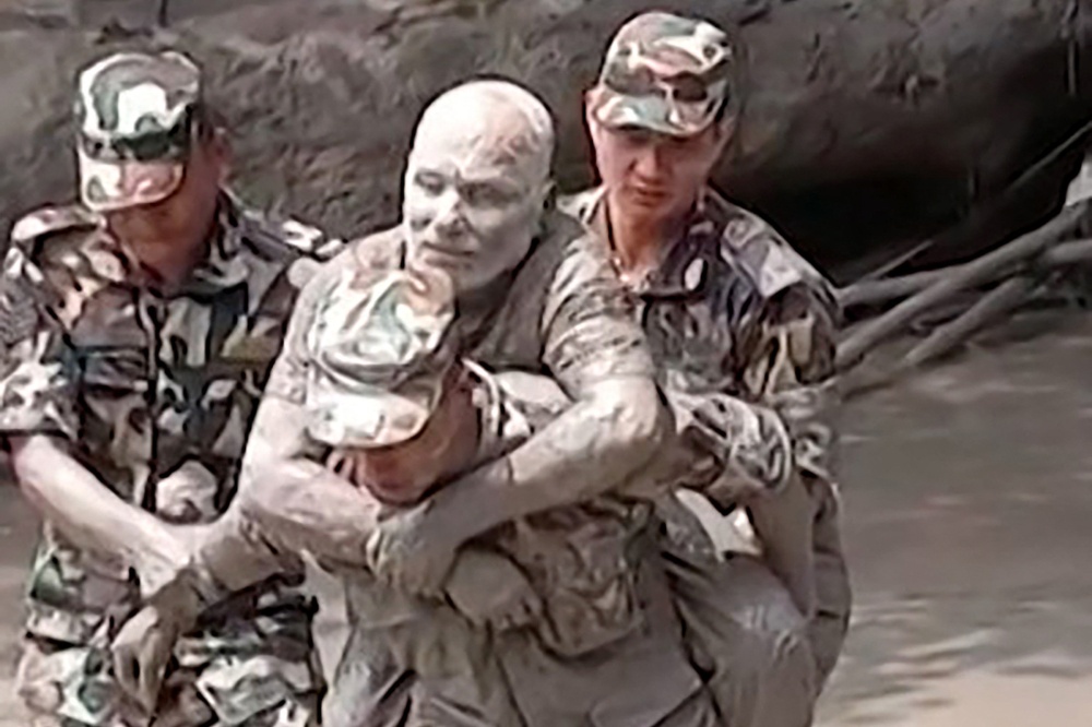 This handout video grab from a UGC footage of Nepal Army taken and released on August 26, 2026 shows a military personnel rescuing a man stranded by massive floods and landslides along the Nepal-Tibet border. — AFP pic  