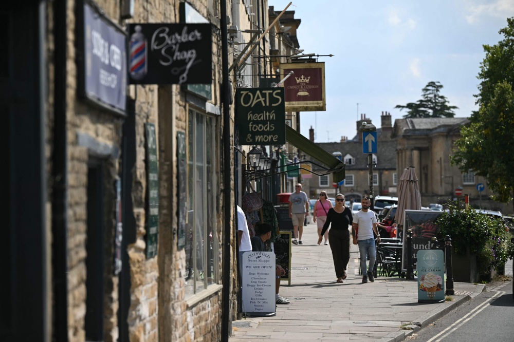 People walk along the main shopping street in Chipping Norton, in Oxfordshire, west of London August 26, 2026. — AFP pic