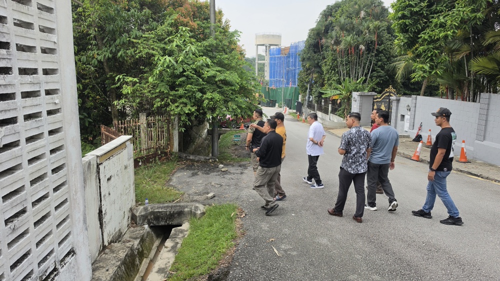 Plainclothes personnel walk along the perimeter of former prime minister Datuk Seri Najib Razak’s residence at Jalan Langgak Duta in Kuala Lumpur on September 19, 2026. — Picture by Milda Hassandarvish
